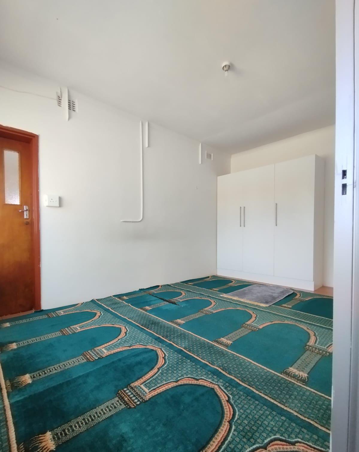 Baytul-Hikmah prayer room with green carpets